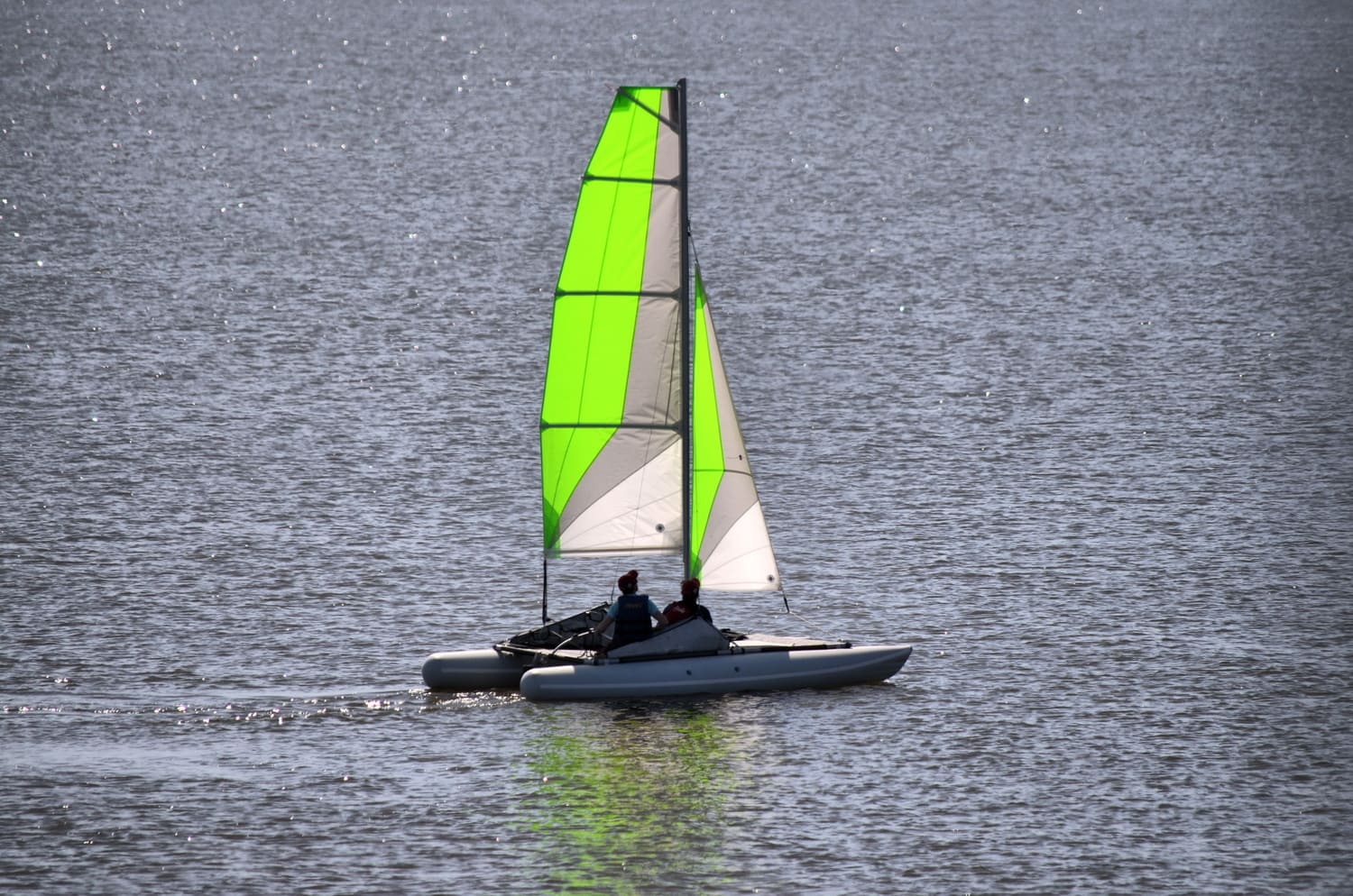 Un catamarán Ducky16 atracado en la orilla de un lago. El Ducky16 es un catamarán familiar versátil diseñado para los amantes de la navegación